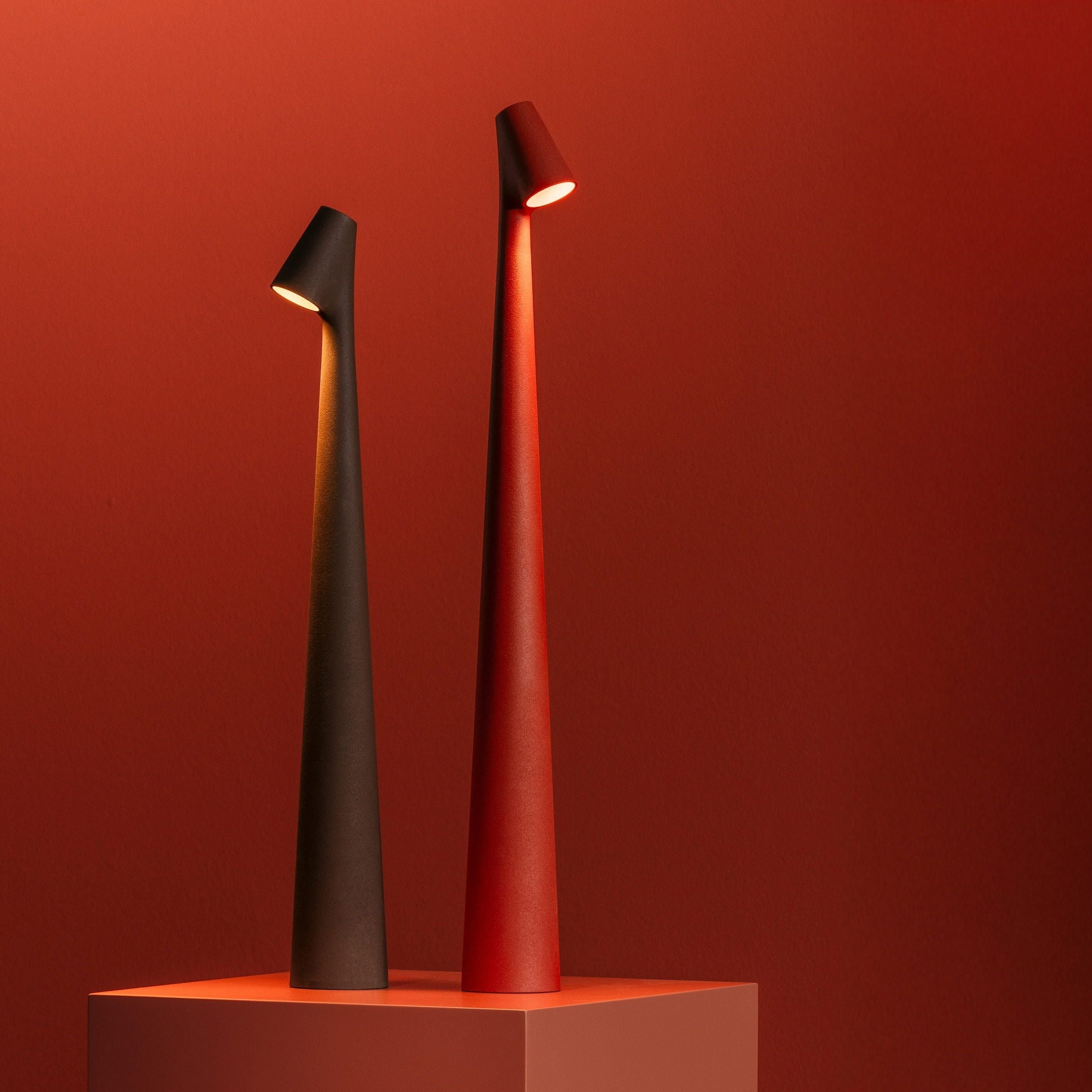 Coppia di lampade ricaricabili senza fili su sfondo rosso.