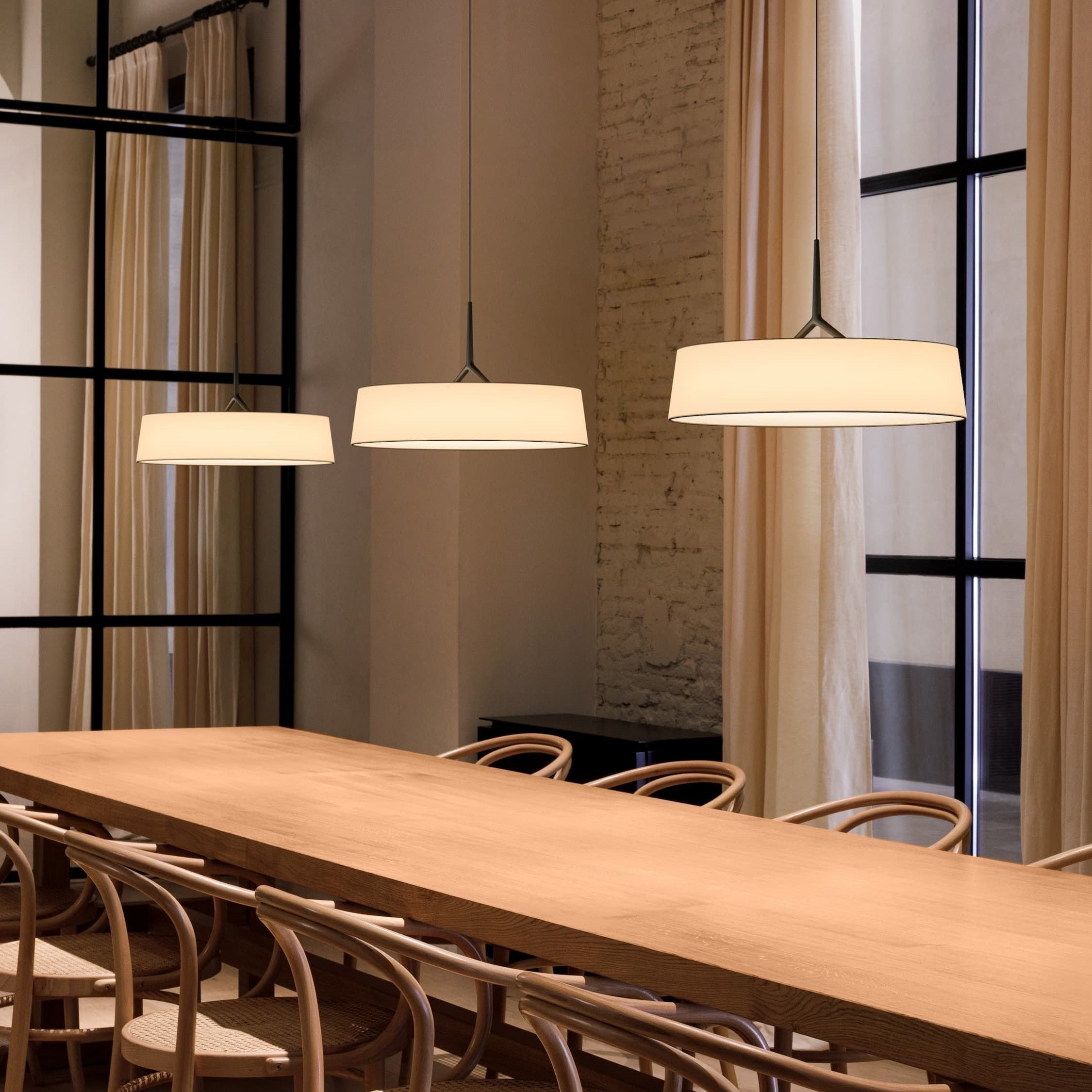 Lampada a sospensione DAMA di Vibia in una sala da pranzo moderna, che mostra la leggerezza visiva del paralume in carta.