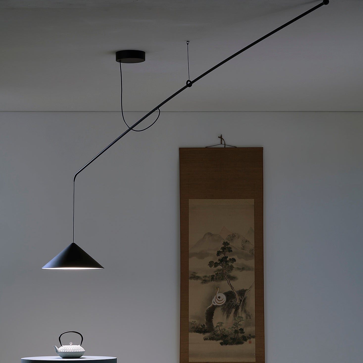 Lampada a sospensione VELA di Martinelli Luce installata sopra un tavolo da pranzo in un living open space. 