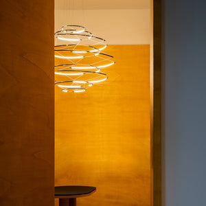 Sospensione Drop 7 Nemo sopra tavolo pranzo in sala contemporanea con luce LED 2700K diffusa che illumina superficie sottostante